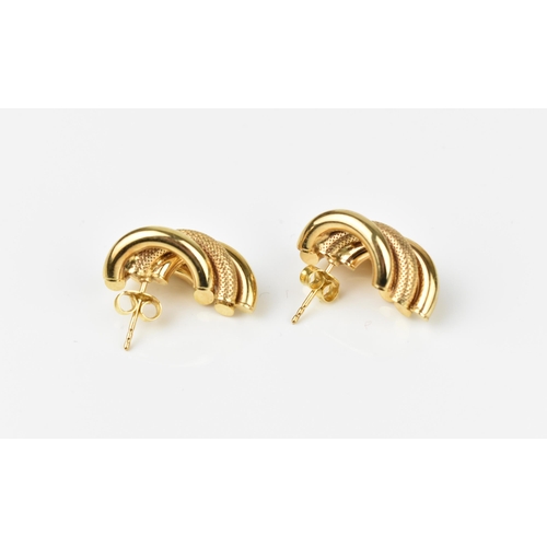 128 - A pair of 9ct yellow gold earrings, designed with alternating textured demi-hoops, combined weight 9... 