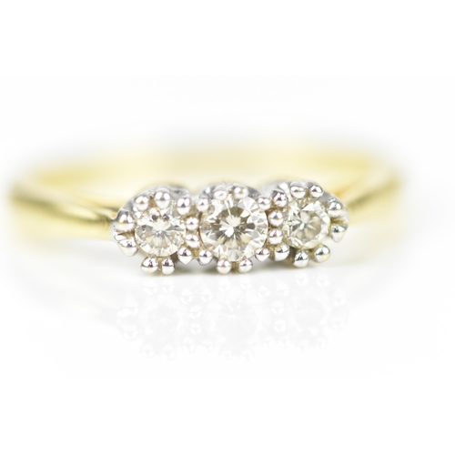 139 - An 18ct yellow gold and three stone diamond ring, the three central stones with double prong white m... 