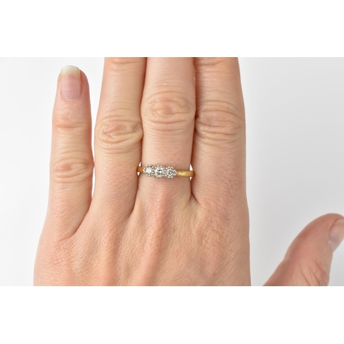 139 - An 18ct yellow gold and three stone diamond ring, the three central stones with double prong white m... 