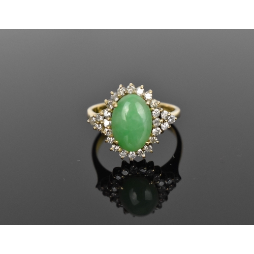 141 - A 14ct yellow gold, diamond and green jade dress ring, with central oval cabochon jade in a halo of ... 