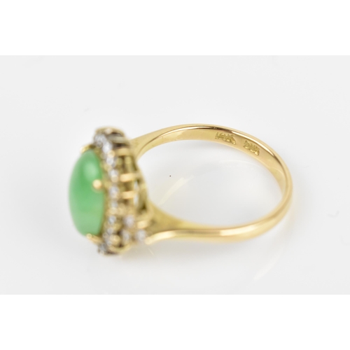 141 - A 14ct yellow gold, diamond and green jade dress ring, with central oval cabochon jade in a halo of ... 