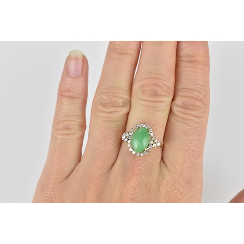 141 - A 14ct yellow gold, diamond and green jade dress ring, with central oval cabochon jade in a halo of ... 