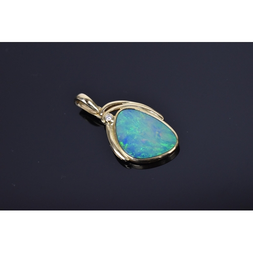 145 - A 15ct yellow gold, black opal and diamond pendant, inset with a central freeform opal in a rub-over... 