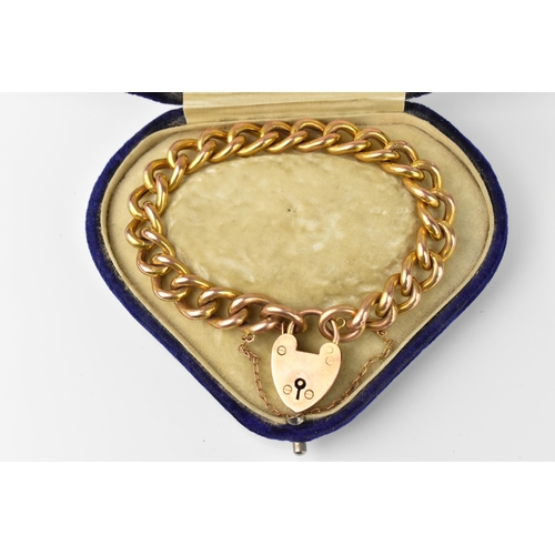 146 - A 9ct yellow gold curb link bracelet with heart padlock and safety chain, in heart shaped fitted box... 