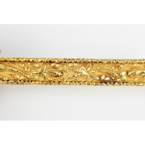 149 - A yellow metal bar brooch, designed with aquatic relief scene on a textured ground, with fish among ... 