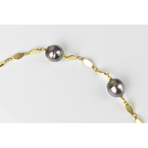 151 - A yellow metal and baroque cultured Tahitian pearl necklace, with three flat links between each pear... 