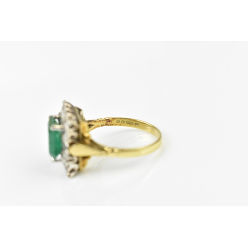 153 - An 18ct yellow gold, emerald and diamond dress ring, with central step cut emerald in a halo of twel... 