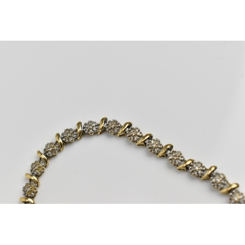 167 - A 9ct yellow gold and diamond bracelet, designed with twenty-seven floral diamond clusters, with cat... 