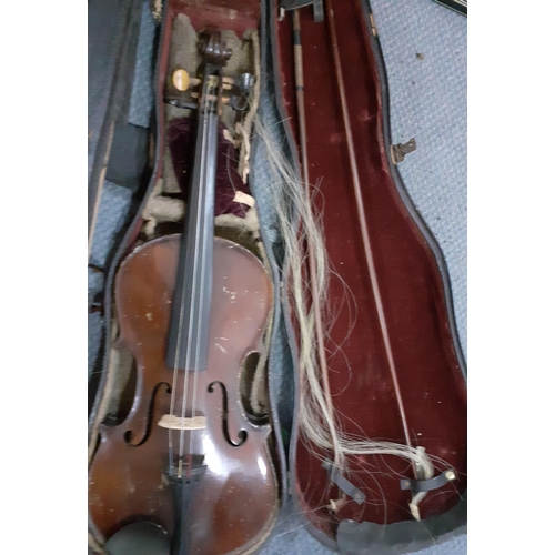 150 - An early 20th century violin, no label, with two bows in a fitted case together with another later v... 