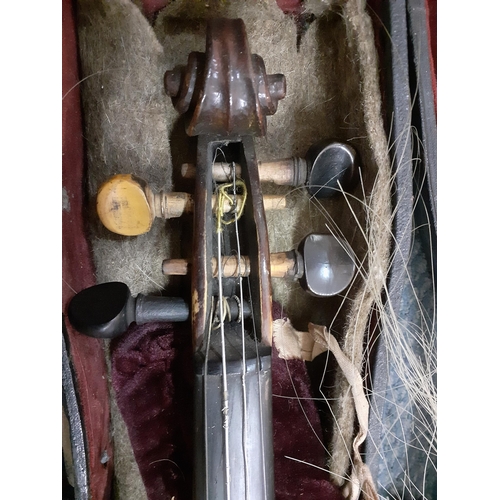 150 - An early 20th century violin, no label, with two bows in a fitted case together with another later v... 