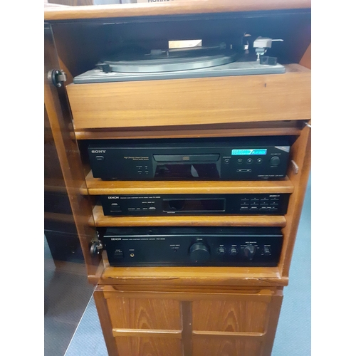 160 - A vintage music system in a teak housing unit with smoky glazed door above a record rack, comprising... 