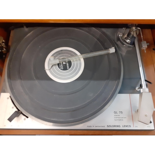 160 - A vintage music system in a teak housing unit with smoky glazed door above a record rack, comprising... 