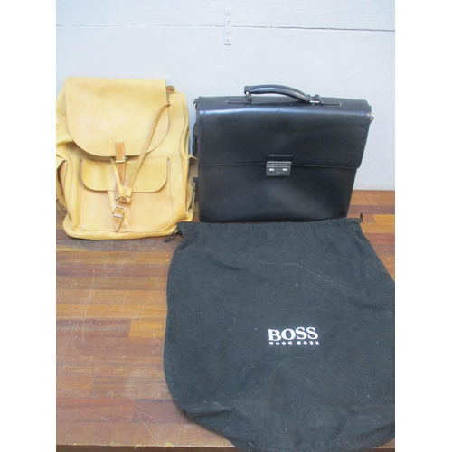 166 - Hugo Boss-A black leather briefcase in branded dustbag with key together with a light brown leather ... 