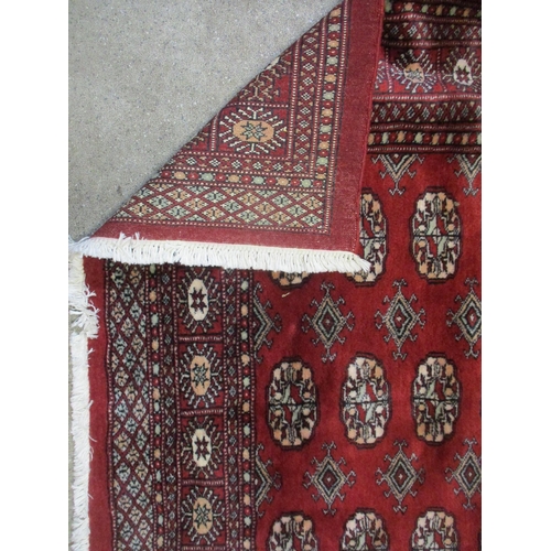 201 - A modern handwoven Middle Eastern red ground rug with elephant gulls, and multiguard border 195cm x ... 