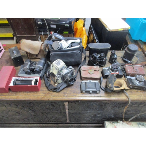 211 - A selection of vintage film cameras, camera accessories, and cased binoculars to include a Nettar ca... 