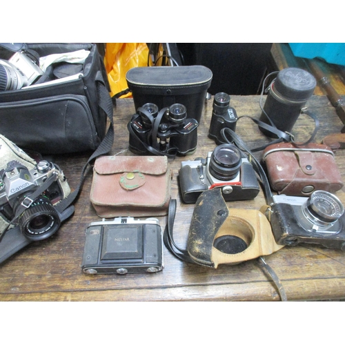 211 - A selection of vintage film cameras, camera accessories, and cased binoculars to include a Nettar ca... 