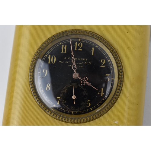 54 - An early 20th century travel/bedside clock having a black dial, with gilt hands, Arabic numerals and... 