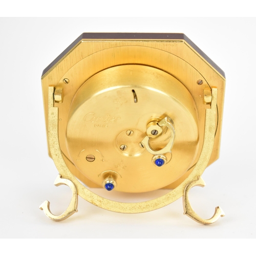 57 - A Cartier manual wind, gilt brass and burgundy enamel travel clock having a white enamel dial with R... 