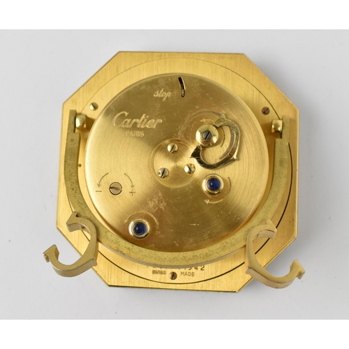 57 - A Cartier manual wind, gilt brass and burgundy enamel travel clock having a white enamel dial with R... 