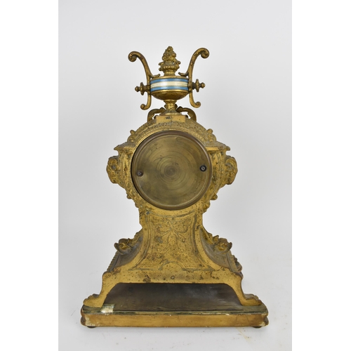 83 - A 19th century French gilt metal mantle clock having a flower shaped finial on a twin handled urn ab... 