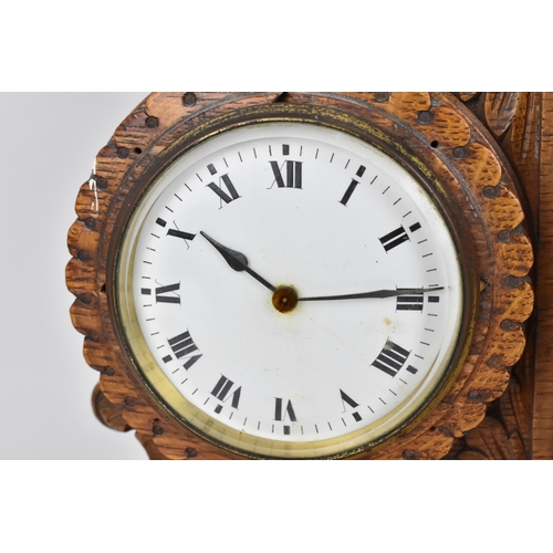 84 - An early 20th century oak combination table clock, barometer and thermometer, having a scroll carved... 