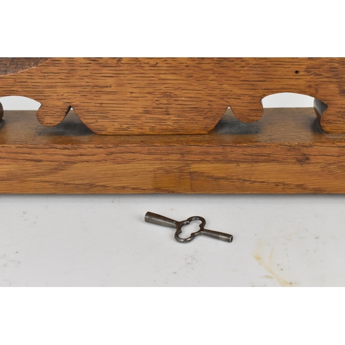 84 - An early 20th century oak combination table clock, barometer and thermometer, having a scroll carved... 