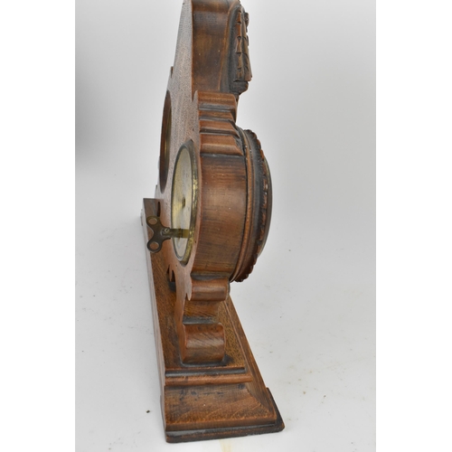 84 - An early 20th century oak combination table clock, barometer and thermometer, having a scroll carved... 