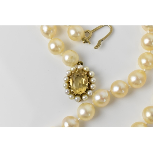 119 - A single strand of cultured white pearls, with 9ct yellow gold, seed pearl and oval cut citrine clas... 