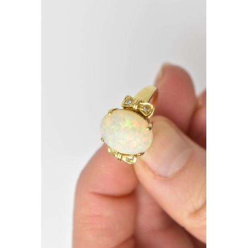 158 - An 18ct yellow gold, opal and diamond dress ring, with central oval cabochon white opal flanked with... 