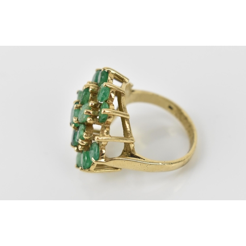 162 - A 9ct yellow gold and emerald cluster dress ring, mounted with eighteen round cut emeralds, one miss... 