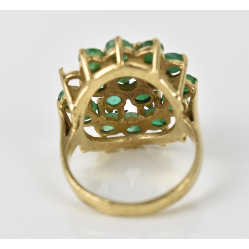 162 - A 9ct yellow gold and emerald cluster dress ring, mounted with eighteen round cut emeralds, one miss... 