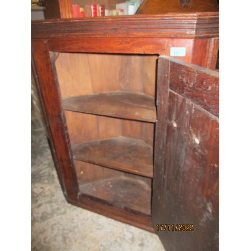 231 - A Georgian oak wall hanging corner cabinet, panelled door with brass handle and lock plate, interior... 