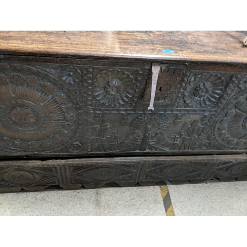 447 - An 18th century Continental, possibly Dutch, oak coffer having a carved front decorated with figures... 