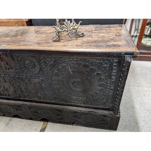 447 - An 18th century Continental, possibly Dutch, oak coffer having a carved front decorated with figures... 