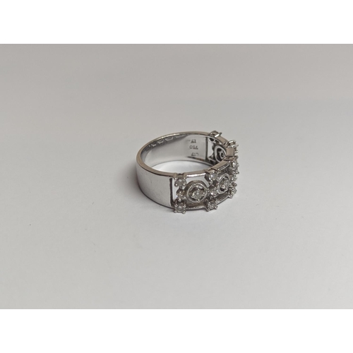 182 - A designer 18ct white gold ring inset with 19 diamonds in a pierced setting 6.4g, along with an unre... 