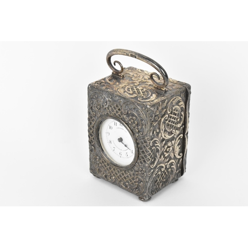 55 - An early 20th century silver cased carriage clock, the embossed case decorated with C scrolls and st... 