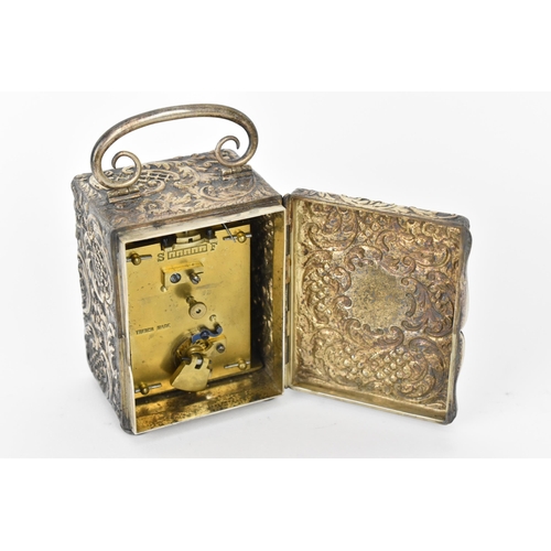 55 - An early 20th century silver cased carriage clock, the embossed case decorated with C scrolls and st... 