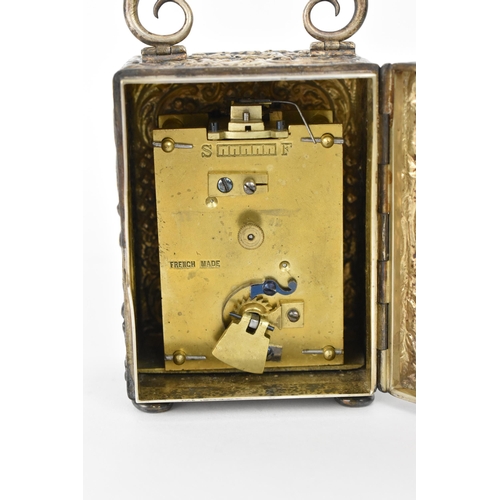 55 - An early 20th century silver cased carriage clock, the embossed case decorated with C scrolls and st... 