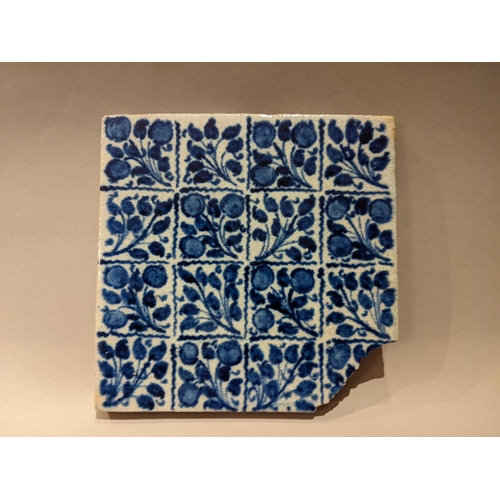 110 - A William de Morgan Persian inspired blue tile with repeating floral patterns with impressed back st... 