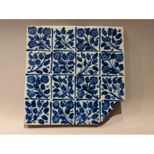 110 - A William de Morgan Persian inspired blue tile with repeating floral patterns with impressed back st... 