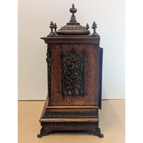 90 - A late 19th/early 20th century oak cased bracket clock, the case having five basket of grape finials... 