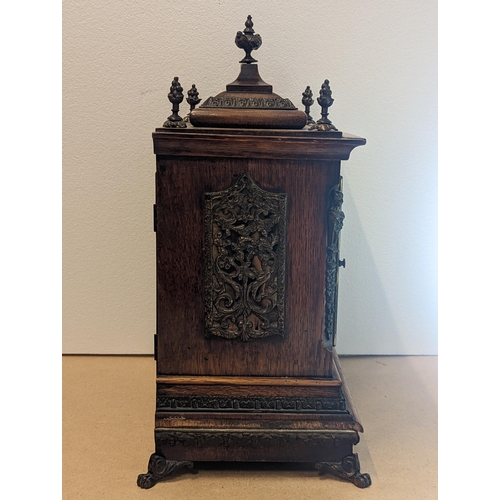 90 - A late 19th/early 20th century oak cased bracket clock, the case having five basket of grape finials... 