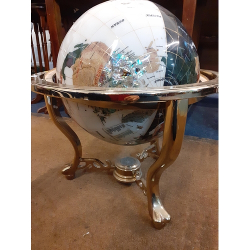 149 - A mineral terrestrial globe with inset abalone in a brass coloured stand with compass uniting 3 lowe... 