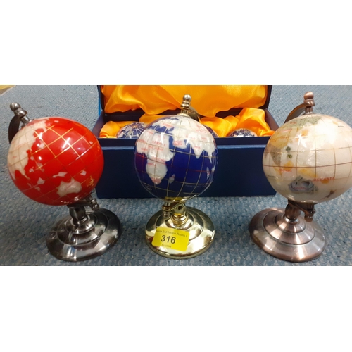 316 - A set of three marble effect globes of small proportions, 16cm high and a cased set of three graduat... 