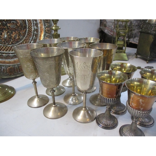 251 - Mixed metal wear to include silver plated goblets, brass candlesticks and a brass Middle Eastern ash... 