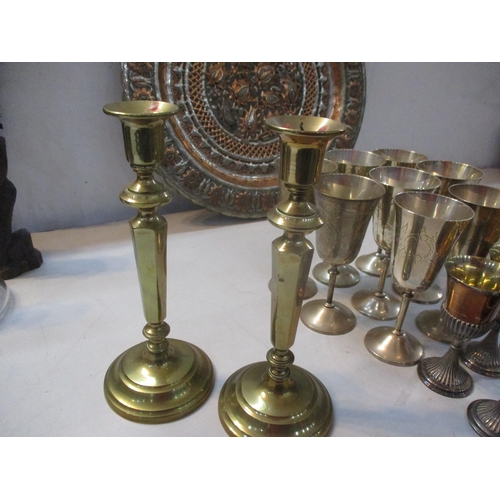 251 - Mixed metal wear to include silver plated goblets, brass candlesticks and a brass Middle Eastern ash... 