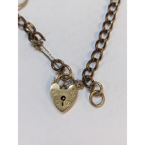 180 - A 9ct gold padlock clasp bracelet A/F with attached 9ct gold ring charm, one inset with white sapphi... 