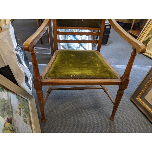 410 - An Arts & Crafts oak armchair, possibly by J S Henry, having scroll terminals and stud back upholste... 