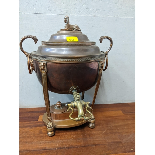 540 - A Georgian copper tea urn with a domed lid and sphinx finial, lion mask ring handles and double burn... 