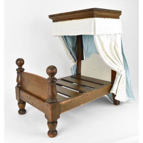 27 - A 19th century doll's half tester bed, with upholstered bed hangings and headboard, on turned feet, ... 